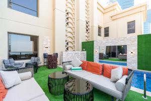 een patio met een bank, stoelen en een zwembad bij ELAN RIMAL SADAF Suites in Dubai