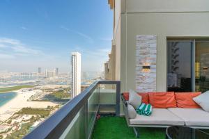 ELAN RIMAL SADAF Suites في دبي: أريكة على شرفة مطلة على المدينة