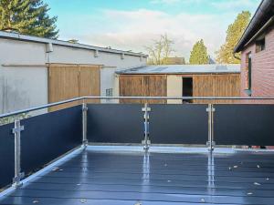 a wooden deck with a metal railing on a house at T&K Apartments - Wegberg - 3-6 Zimmer Apartments in Wegberg