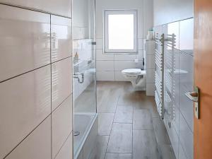 a white bathroom with a toilet and a window at T&K Apartments - Wegberg - 3-6 Zimmer Apartments in Wegberg +42 photos