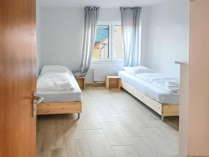 sypialnia z 2 łóżkami i oknem w obiekcie T&K Apartments - Wegberg - 3-6 Zimmer Apartments w mieście Wegberg
