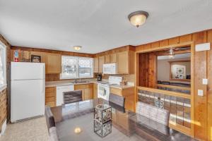 a kitchen with wooden cabinets and a white refrigerator at Downtown 2 story property apts in Spearfish