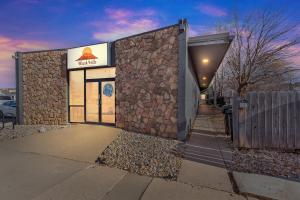 a building with a stone wall next to a fence at Downtown 2 story property apts in Spearfish