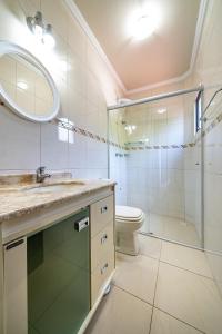 y baño con lavabo, ducha y aseo. en 151 - Casa Triplex apenas a 80m da Praia de Bombas, en Bombinhas