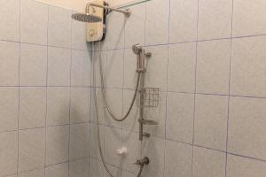 a shower with a shower head in a bathroom at Captal Beach Villa in Mathiveri
