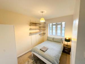 a small bedroom with a bed and a window at 2 Bed Flat - 5 min walk from Brent Cross Station in Hendon