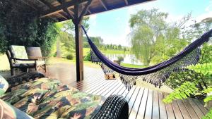 a hammock on a deck with a view of a lake at Rancho Otto Chalet Boutique - Rancho Queimado - SC in Rancho Queimado