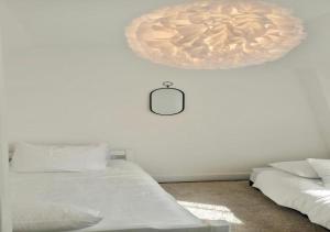 a bedroom with two beds and a clock on the wall at LIVABLŌM "Maison et Parking Privée" in Guesnain