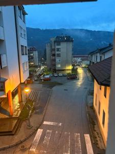 an empty street with cars parked in a city at Stan na dan - Foča in Foča