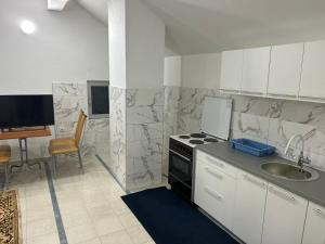 a kitchen with a stove and a sink and a table at Stan na dan - Foča in Foča