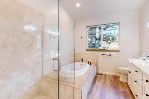 un baño con bañera y ducha de cristal en Koyukon Escape, en South Lake Tahoe 18 fotos más