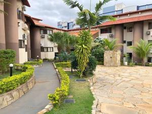 a walkway in front of a building with trees and plants at Recanto das Águas Apart in Rio Quente