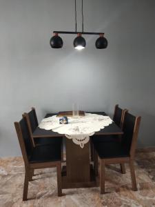 a dining room table with chairs and aendant light at Apartamento aconchegante com ar condicionado de 22 a 8h in Rio de Janeiro