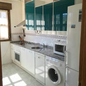uma cozinha com uma máquina de lavar roupa e um frigorífico em Casa La Xana del Valle em Llanes