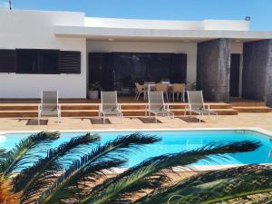 dos fotos de una piscina y una casa en Casa Airalba en Tías