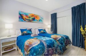 a bedroom with two beds with blue comforters at Naples Dream at WTC with Heated Pool SPA Sauna 7 bicycles and 3 mls to beach in Naples