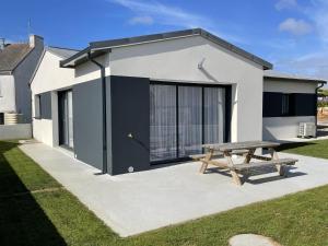 ein Haus mit einem Picknicktisch davor in der Unterkunft Villa Plain-Pied Vue Mer in Lanildut