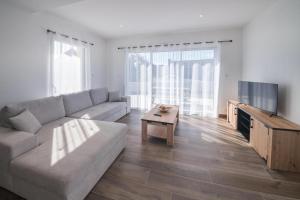 ein Wohnzimmer mit Couch und Fernseher in der Unterkunft Villa Plain-Pied Vue Mer in Lanildut