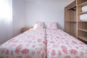 ein Schlafzimmer mit einem Bett mit geblümter Tagesdecke in der Unterkunft Villa Plain-Pied Vue Mer in Lanildut