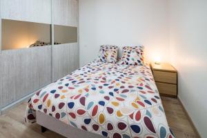 ein Schlafzimmer mit einem großen Bett mit einer bunten Bettdecke in der Unterkunft Villa Plain-Pied Vue Mer in Lanildut