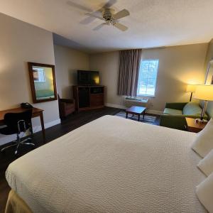 um quarto de hotel com uma cama grande e um sofá em Baymont by Wyndham Mackinaw City em Mackinaw City
