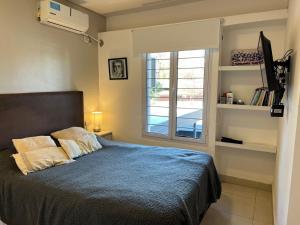 a bedroom with a blue bed and a window at Casa ALI, cuenta con 4 camas individuales y una cama matrimonial, capacidad máxima 6 personas in Yerba Buena