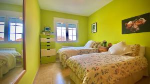 a bedroom with two beds and yellow walls at Puy du Fou alojamiento de Julieta in Bargas