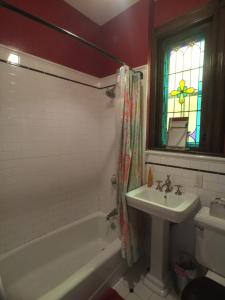 baño con bañera, lavabo y ventana en Amazing 3 Bedroom Apartment en Nueva York