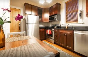kuchnia z drewnianymi szafkami i białą lodówką w obiekcie Amazing 3 Bedroom Apartment w Nowym Jorku