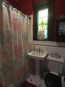 ein Bad mit einem Waschbecken, einem WC und einem Fenster in der Unterkunft Amazing 3 Bedroom Apartment in New York