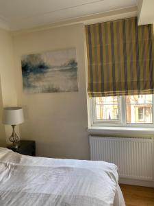 a bedroom with a white bed and a window at Central London Double Bedroom by Station in London