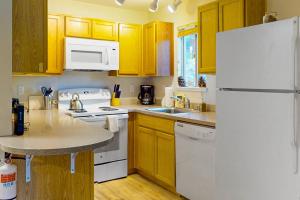 a kitchen with white appliances and wooden cabinets at Stagecoach Ski Condo in Stateline