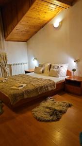 a bedroom with a large bed and a rug at Guest House Karov - 2 Stars in Chepelare