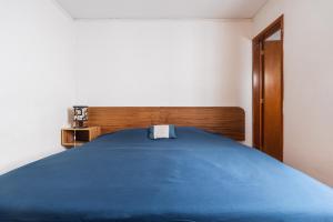 een slaapkamer met een blauw bed en een houten hoofdeinde bij heart of Roma Apt on a quiet street in Mexico-Stad