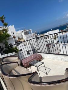 balkon z 2 krzesłami i stołem na balkonie w obiekcie chez Abdou house with ocean view w mieście Tanger