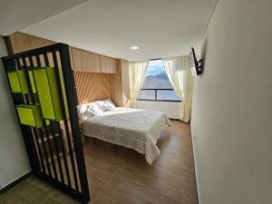 ein kleines Schlafzimmer mit einem Bett und einem Fenster in der Unterkunft Apartamento Meredi in Bogotá