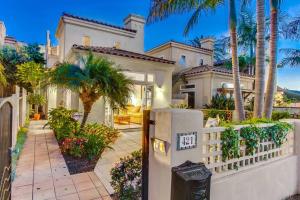 een groot wit huis met palmbomen en een hek bij Large Luxury Beach House with Rooftop Views! in San Diego