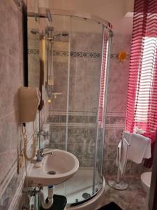 uma casa de banho com um lavatório e um chuveiro em Room e Breakfast Diana e Ninni Salsomaggiore Terme em Salsomaggiore Terme