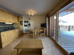 eine Küche und ein Esszimmer mit einem Tisch und einem Balkon in der Unterkunft Appartement Saint-Martin-de-Belleville, 2 pièces, 4 personnes - FR-1-452-193 in Saint-Martin-de-Belleville