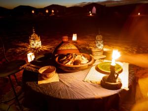 un tavolo con una candela e una ciotola di cibo di Caravane de Reve a M'Hamid