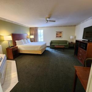 um quarto de hotel com uma cama e um sofá em Baymont by Wyndham Mackinaw City em Mackinaw City