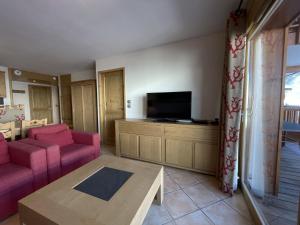 ein Wohnzimmer mit einem Sofa und einem Flachbild-TV in der Unterkunft Appartement Saint-Martin-de-Belleville, 4 pièces, 6 personnes - FR-1-452-133 in Saint-Martin-de-Belleville