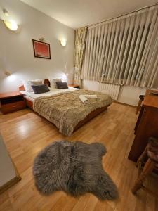 a bedroom with two beds and a rug on the floor at Guest House Karov - 2 Stars in Chepelare