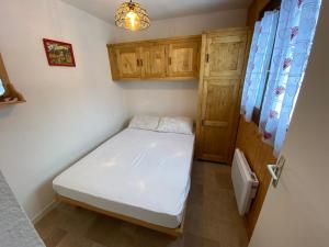 Mały pokój z białym łóżkiem i drewnianymi szafkami w obiekcie Bel appartement à Châtel près du centre et des télécabines, avec Multi Pass été à 3€/jour/personne - FR-1-693-63 w mieście Châtel