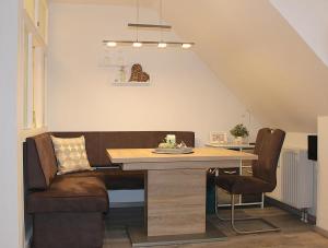 a dining room with a table and a couch at Apartmentvermittlung Mehr als Meer - Objekt 15 in Niendorf