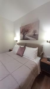 a bedroom with a white bed with a painting on the wall at G&K House View in Messini