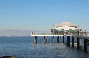a pier with a building on top of the water at Apartmentvermittlung Mehr als Meer - Objekt 15 in Niendorf