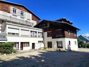 un edificio blanco con techo negro junto a otro edificio en Studio Méaudre, 1 pièce, 6 personnes - FR-1-737-77 en Méaudre