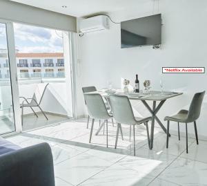 a dining room with a table and chairs and a tv at Nissi Avenue Suites in Ayia Napa