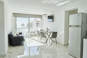 a kitchen and living room with a table and chairs at Nissi Avenue Suites in Ayia Napa